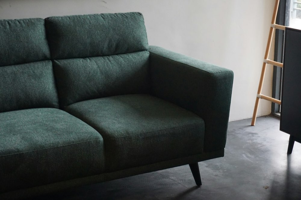 A three-seat sofa in forest-green weave